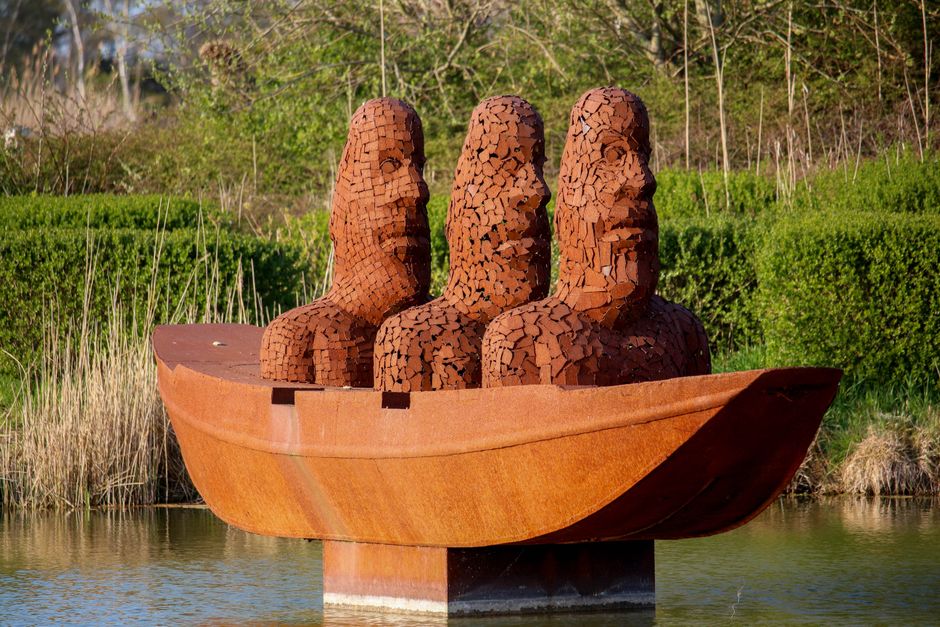 Houten beeld van vogel op stenen terras.